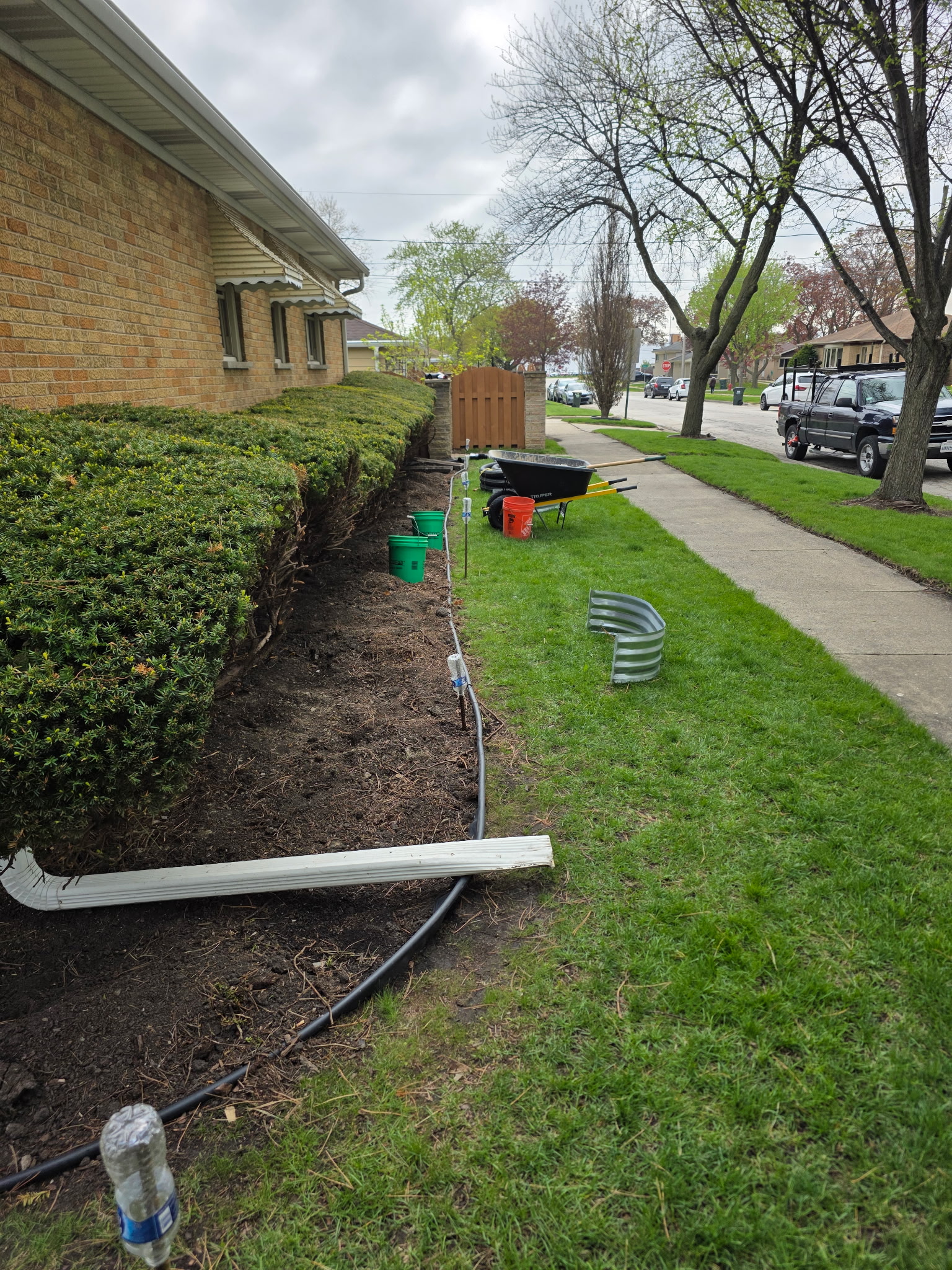 French drain pipe and downspout extension materials staged on site
